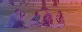 A group of college students sitting in a field